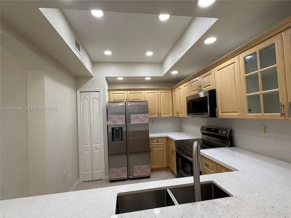 a kitchen with stainless steel appliances a refrigerator and a sink