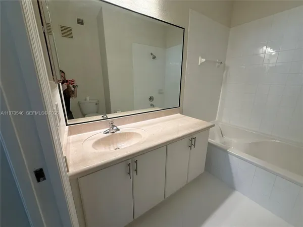 a bathroom with a granite countertop sink a toilet and shower