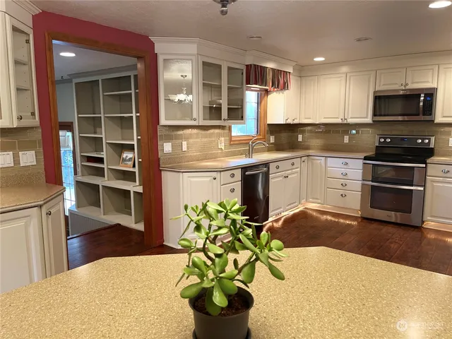 a kitchen with stainless steel appliances a stove a sink a microwave and cabinets