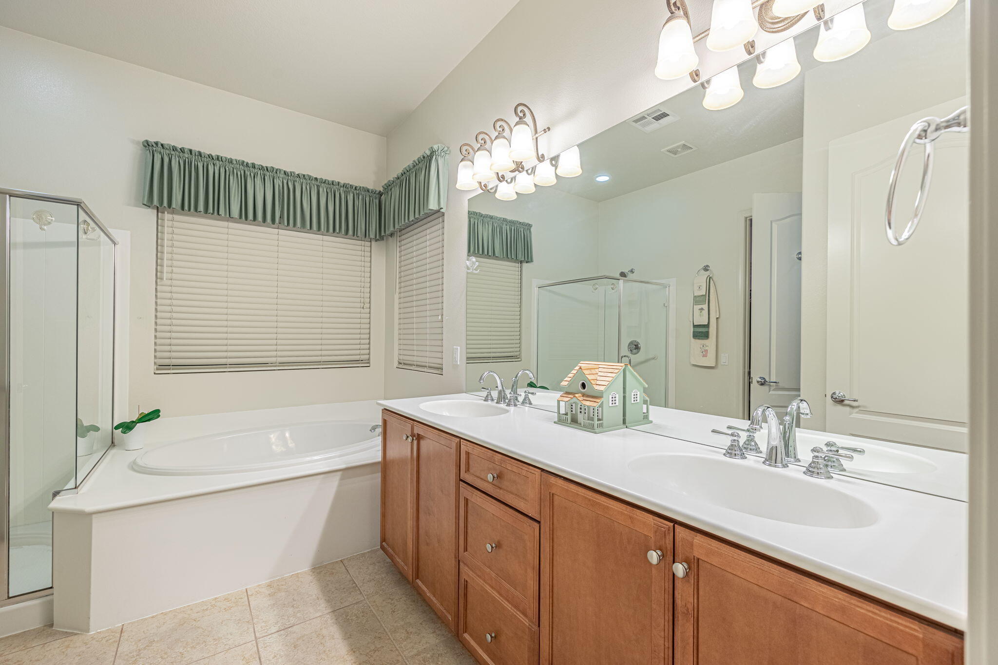6827 Cabernet Road Palmdale, CA 93551 - Photo 36 of 50 a bathroom with a double vanity sink a large mirror and a bathtub