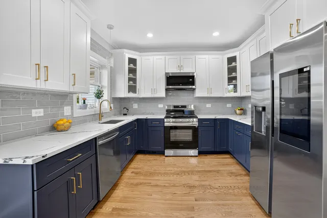 a large kitchen with stainless steel appliances granite countertop a stove a sink dishwasher a refrigerator and a microwave