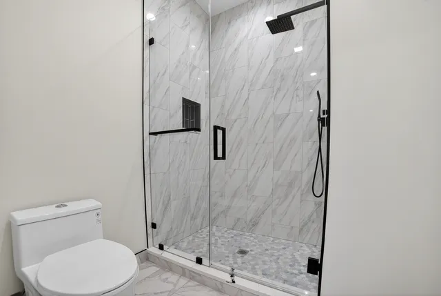 a bathroom with a toilet and a shower