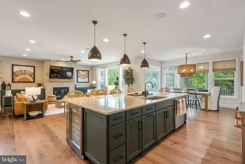 a kitchen with lots of counter space a sink appliances and living room view