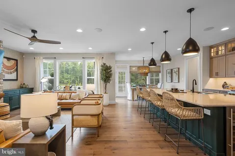 a view of a dining room and livingroom with furniture wooden floor a chandelier