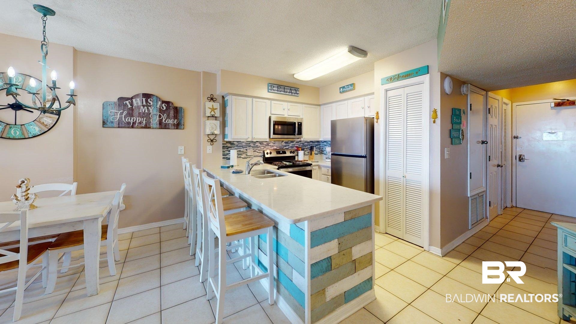 645 Plantation Road, Unit 6503 Gulf Shores, AL 36542 - Photo 9 of 53 Kitchen featuring white cabinets, light tile patterned floors, backsplash, appliances with stainless steel finishes, and pendant lighting