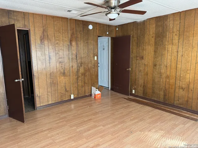 an empty room with wooden floor and entryway