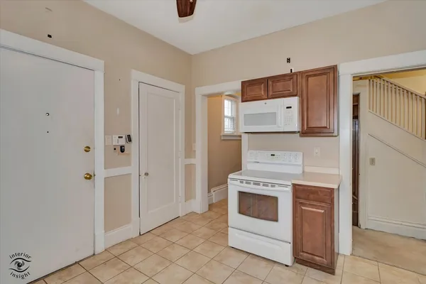 a kitchen with white cabinets and white appliances