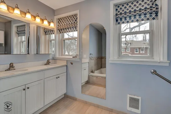 a spacious bathroom with a double vanity sink a mirror and a shower