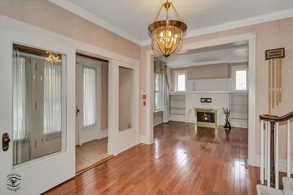 a view of a hallway with wooden floor and chandelier
