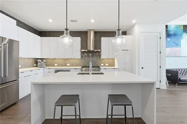 a kitchen with refrigerator a sink and chairs