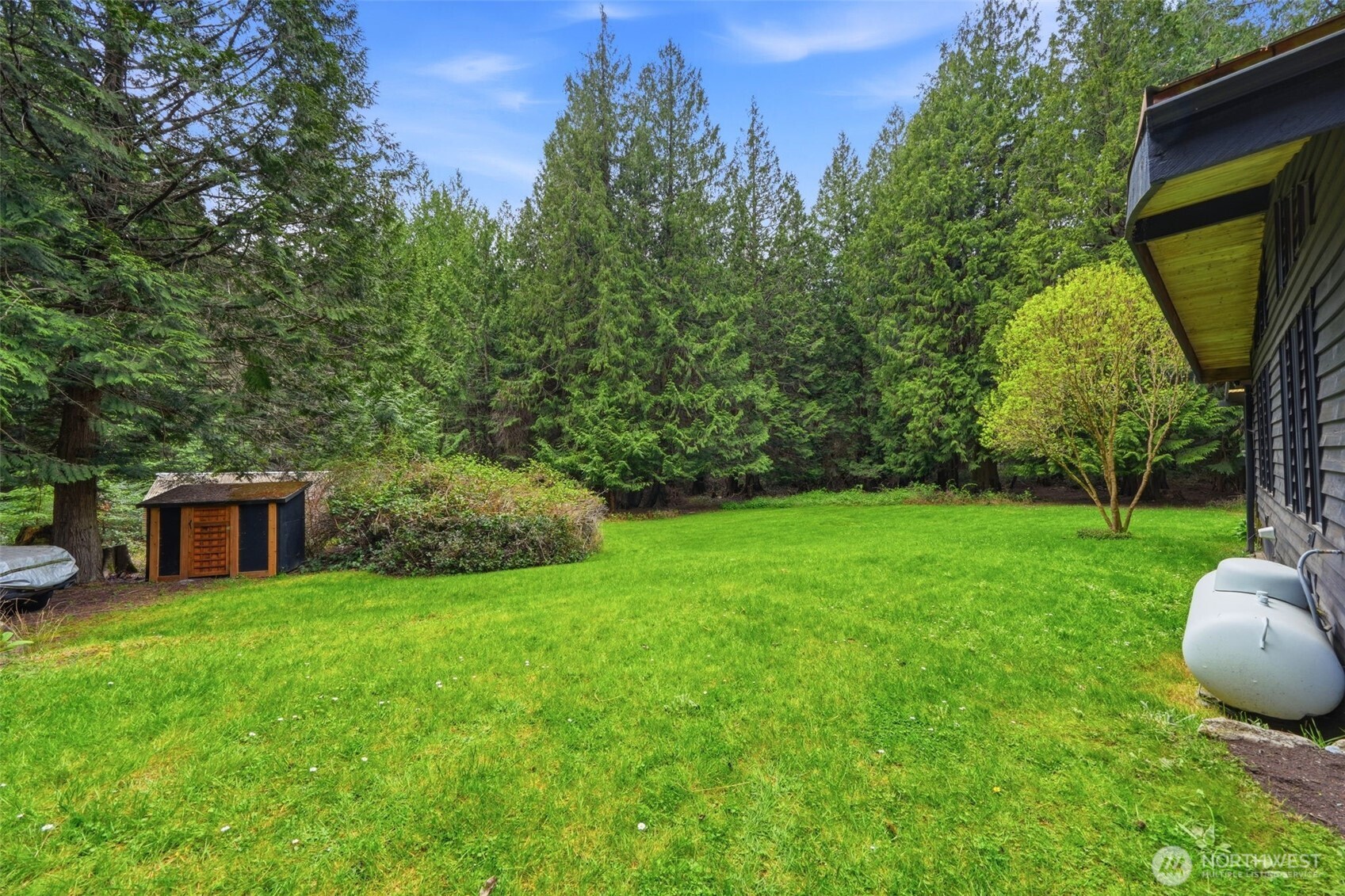 102 Byron Road Friday Harbor, WA 98250 - Photo 19 of 40 a view of a backyard with table and chairs and potted plants and large tree