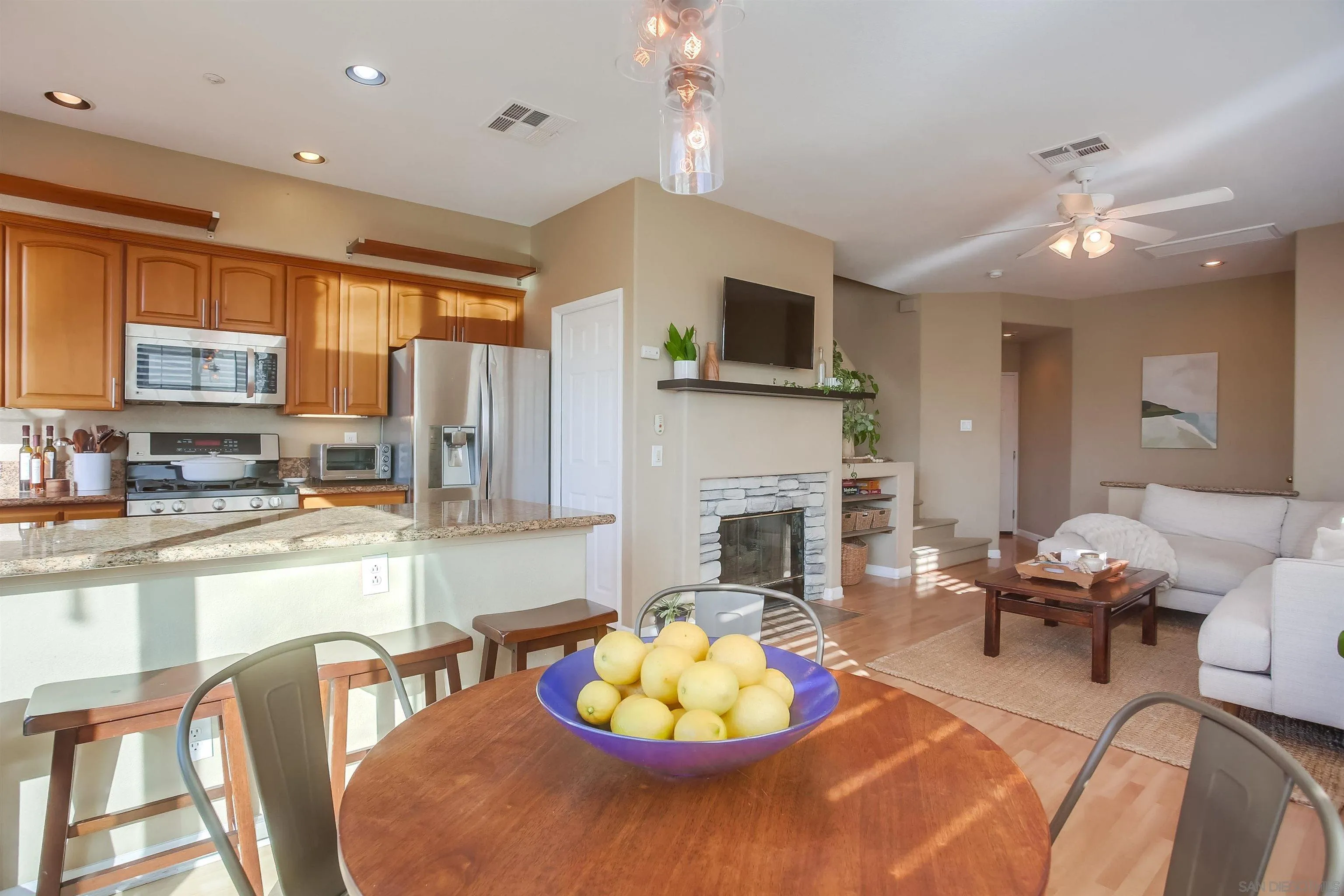 382 Carmel Creeper Place Encinitas, CA 92024 - Photo 11 of 43 a living room with furniture a fireplace and a kitchen view