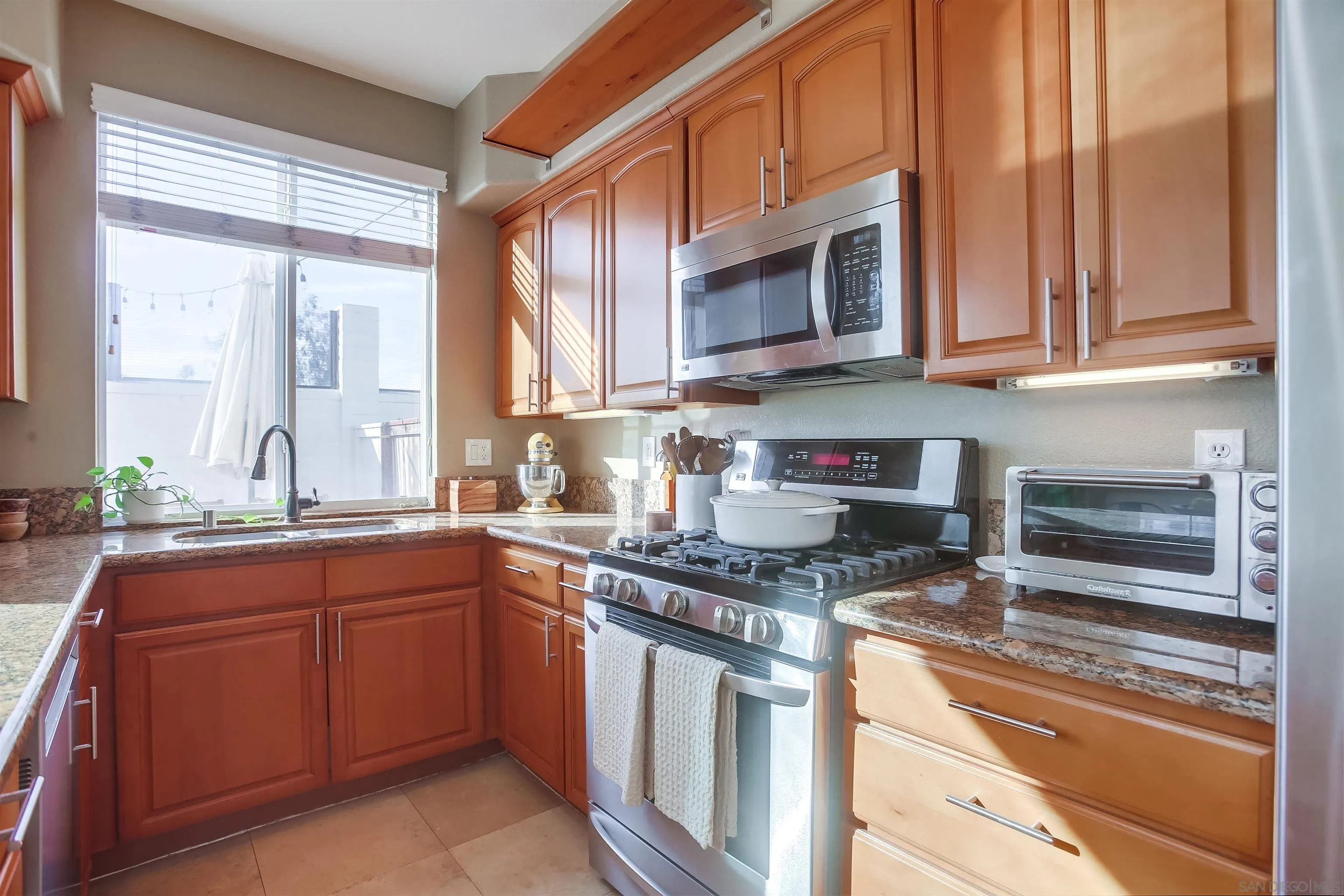 382 Carmel Creeper Place Encinitas, CA 92024 - Photo 13 of 43 a kitchen with stainless steel appliances granite countertop a stove a sink and a microwave