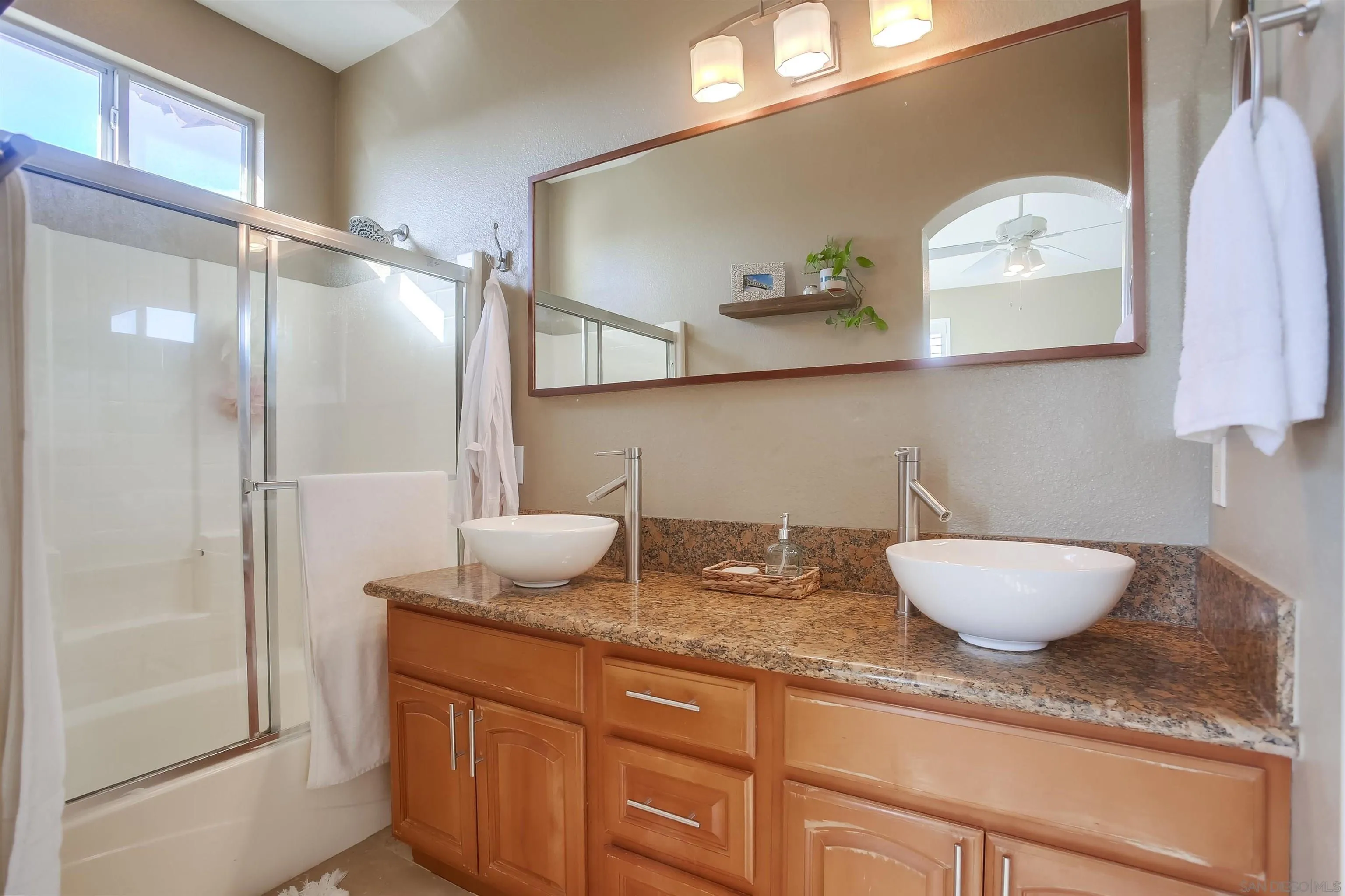 382 Carmel Creeper Place Encinitas, CA 92024 - Photo 29 of 43 a bathroom with a granite countertop sink a mirror and shower