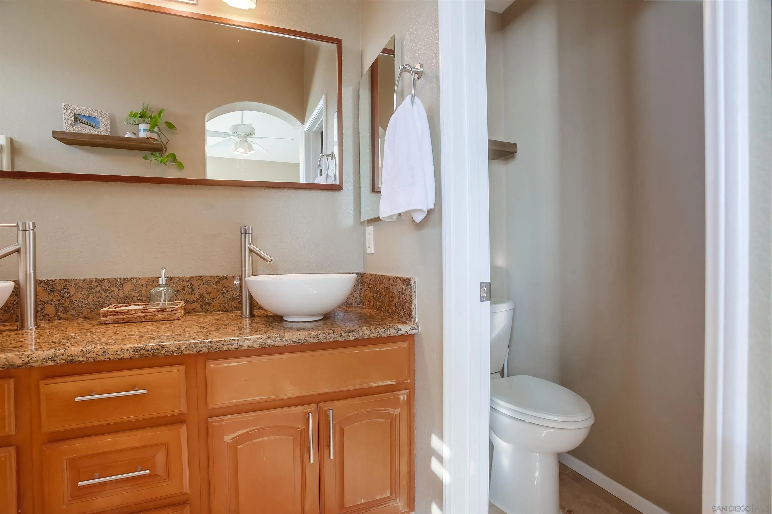 382 Carmel Creeper Place Encinitas, CA 92024 - Photo 31 of 43 a bathroom with a granite countertop sink a toilet and a mirror