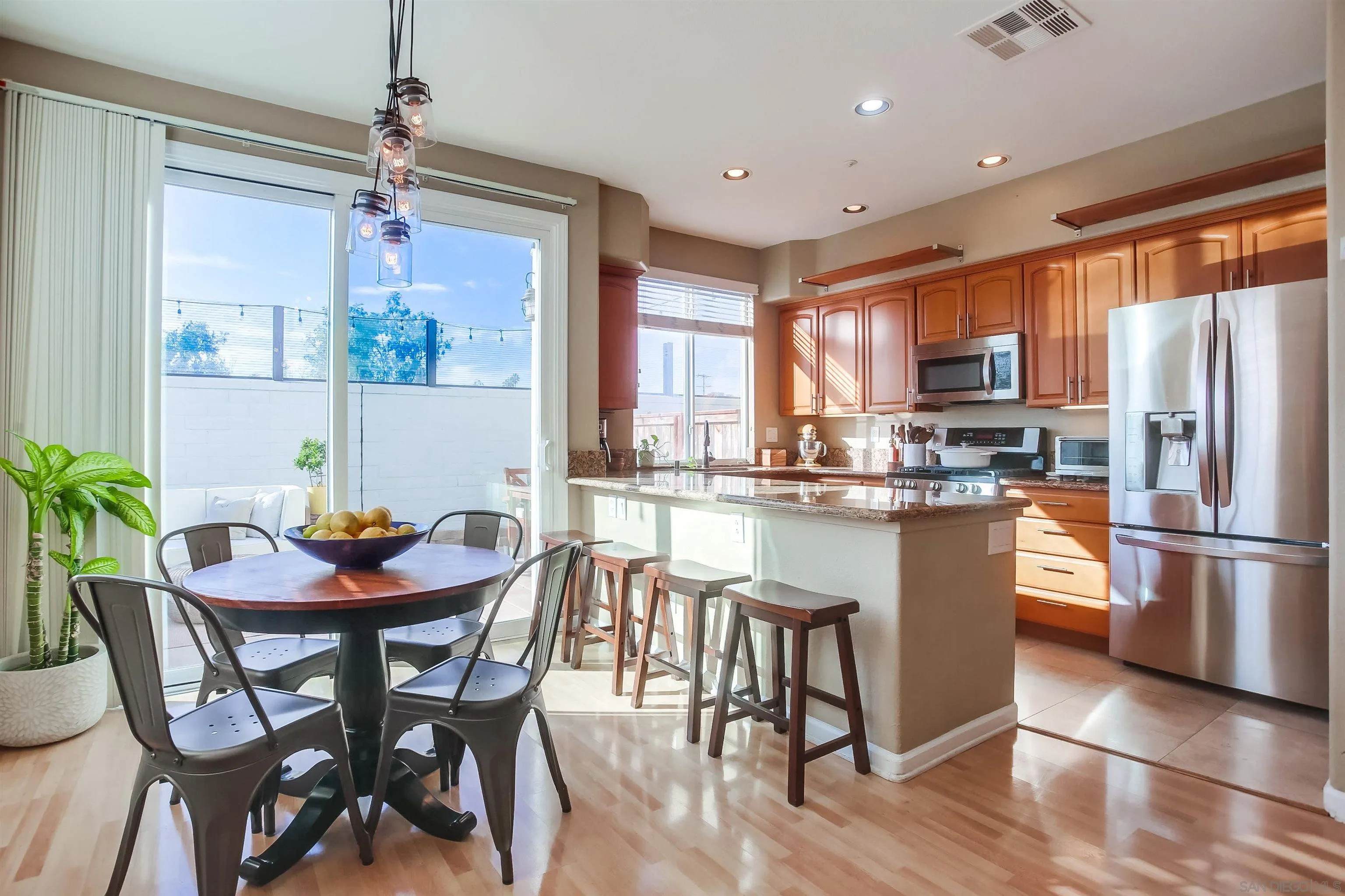 382 Carmel Creeper Place Encinitas, CA 92024 - Photo 9 of 43 a kitchen with stainless steel appliances granite countertop a dining table chairs refrigerator and sink