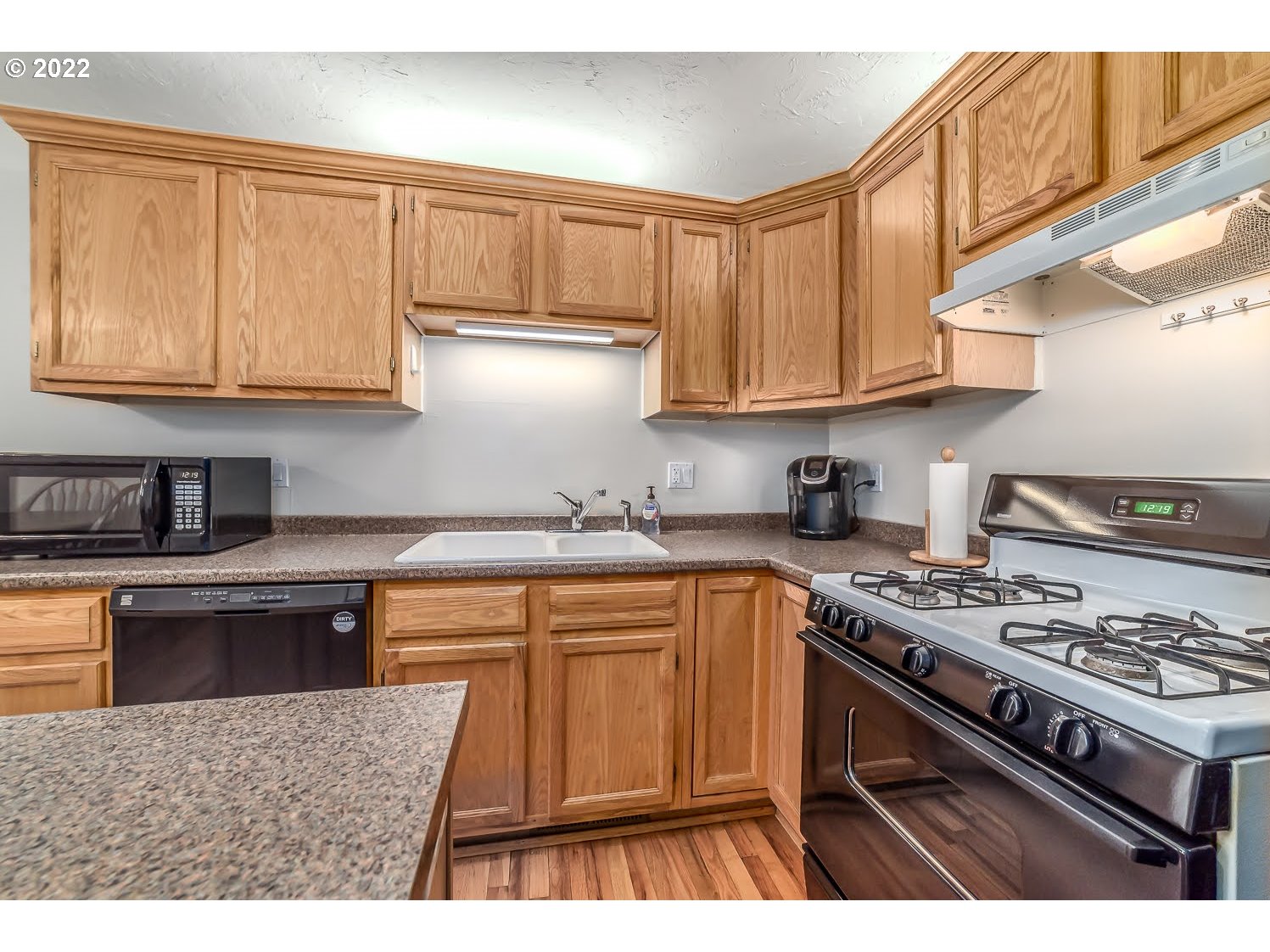 331 South 46th Street Springfield, OR 97478 - Photo 14 of 28 a kitchen with stainless steel appliances granite countertop a stove a sink dishwasher and cabinets with wooden floor