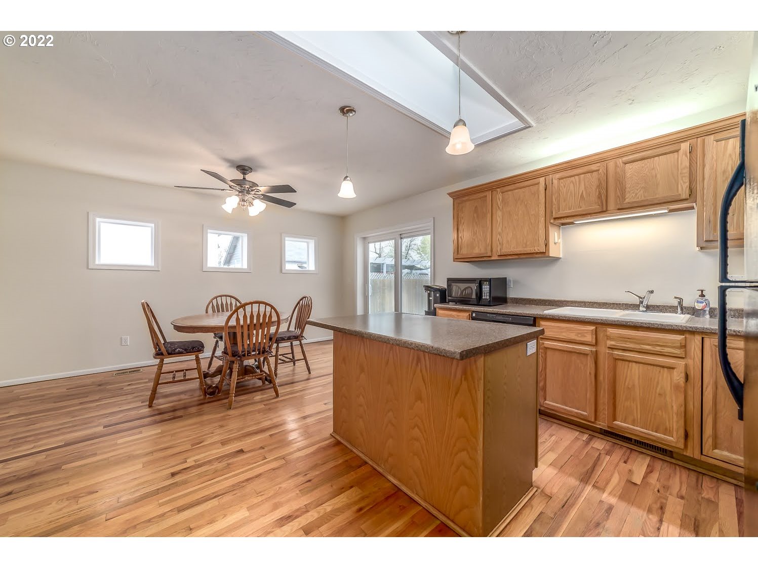 331 South 46th Street Springfield, OR 97478 - Photo 10 of 28 a kitchen with stainless steel appliances granite countertop a stove top oven a sink a dining table and chairs with wooden floor
