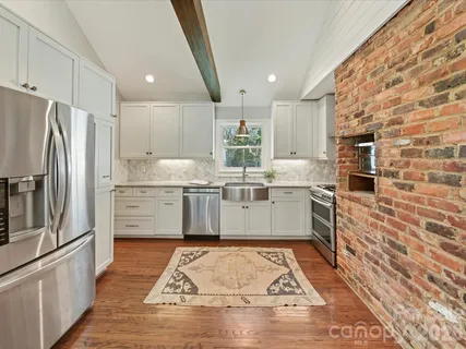 a kitchen with stainless steel appliances granite countertop a refrigerator oven a sink and dishwasher