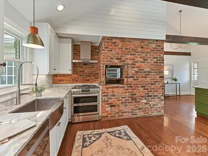 a kitchen with granite countertop a sink wooden floor and counter space