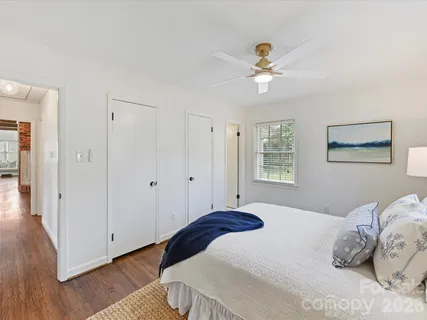 a bedroom with a large bed and a chandelier