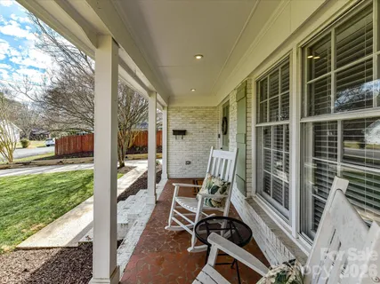 a balcony with chairs and with a large window