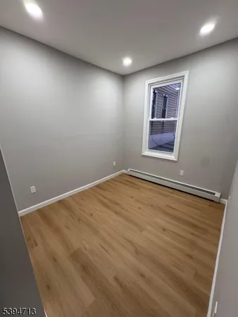 an empty room with a wooden floor and windows