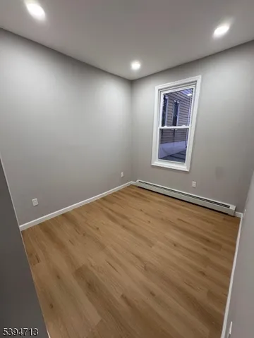 an empty room with a wooden floor and windows