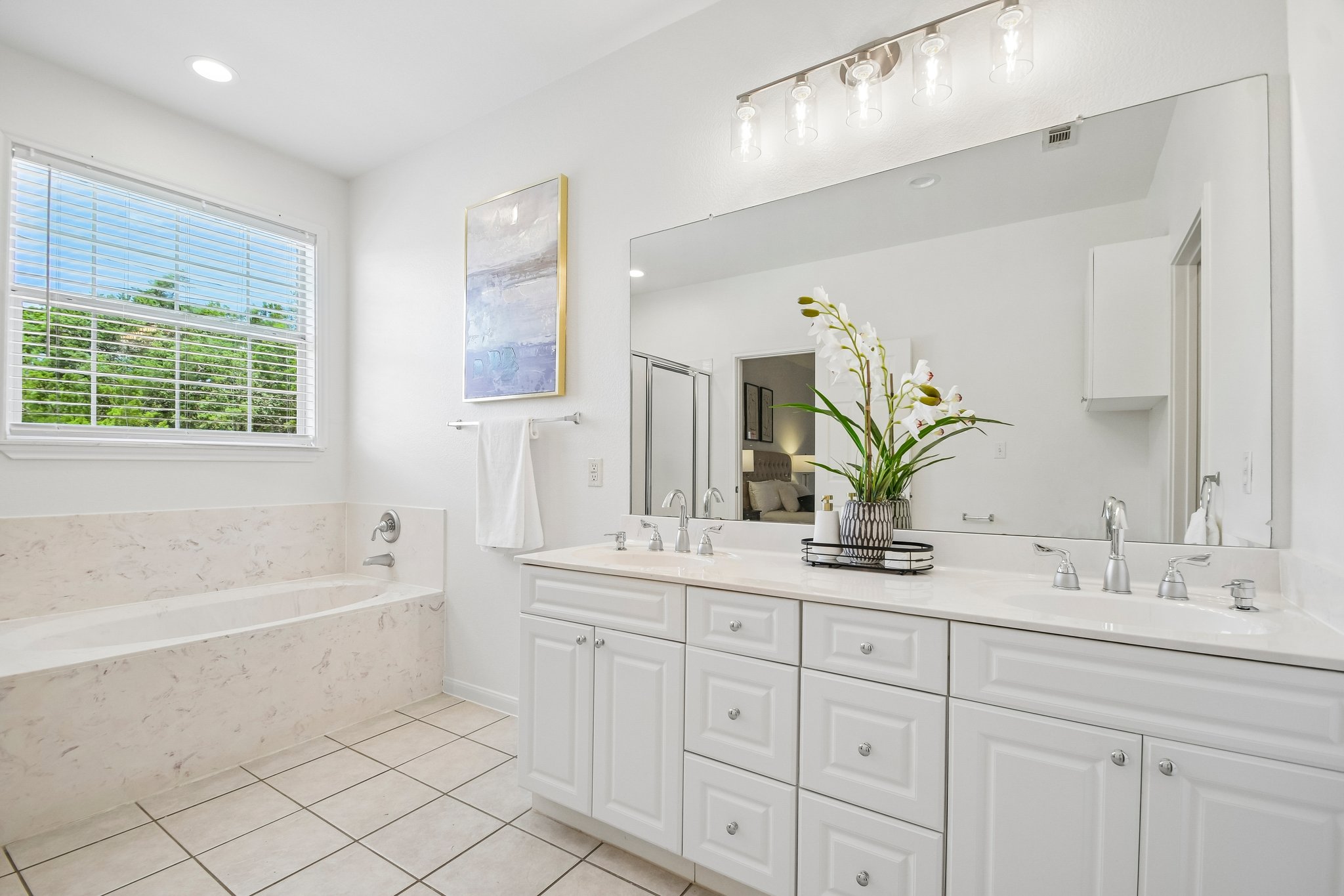 20609 Bridle Path Road Lago Vista, TX 78645 - Photo 4 of 30 Bright and airy, this primary bathroom provides a soaking tub and a spacious double vanity with ample storage.