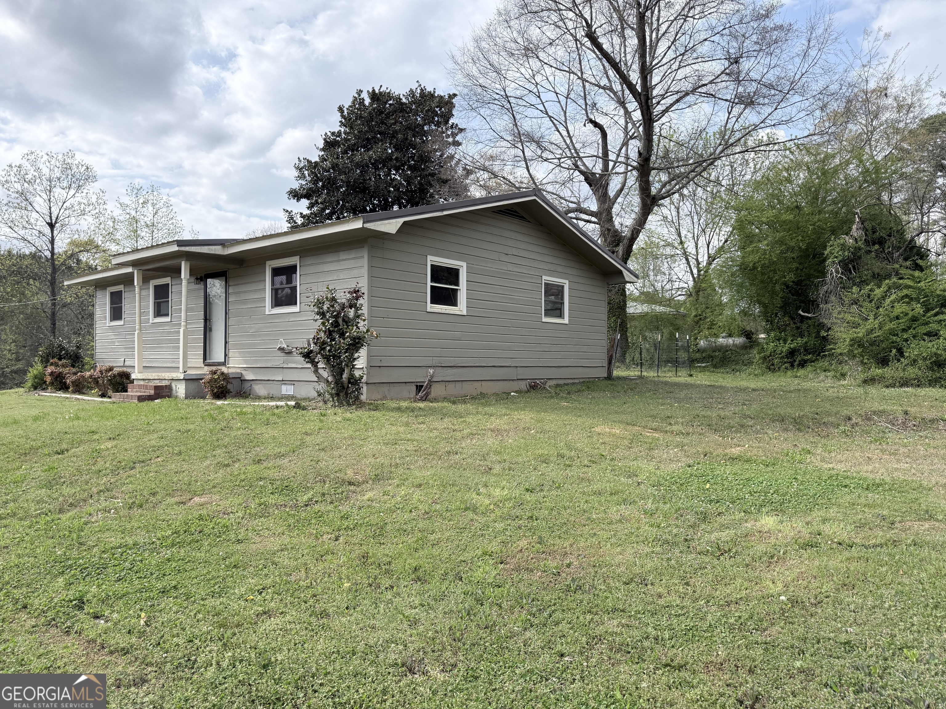 605 Perryman Bridge Road Heflin, AL 36264 - Photo 42 of 52 a backyard of a house with potted plants and large tree