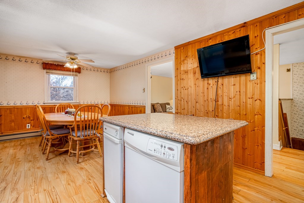 155 Groton Road Shirley, MA 01464 - Photo 8 of 42 a dining hall with stainless steel appliances granite countertop a sink a dining table and chairs with wooden floor