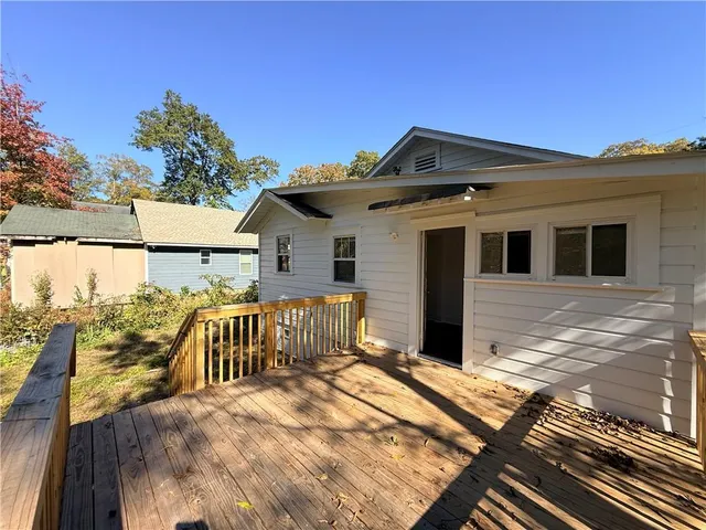 a view of a house with wooden floor next to a yard