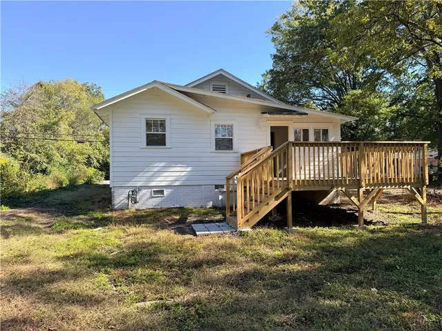 a view of a house with a yard and deck