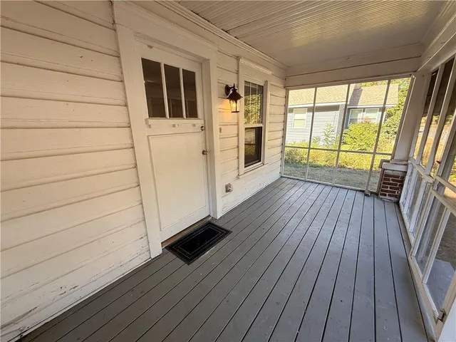 a view of front door deck and wooden floor