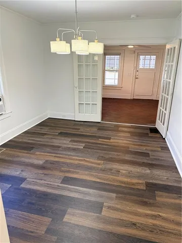 a view of empty room with window and wooden floor