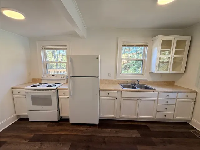 a kitchen with white cabinets and white appliances