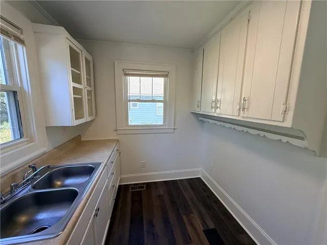 a room with wooden floor and cabinets