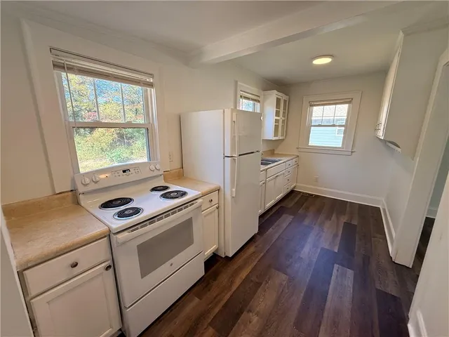 a kitchen with wooden floors and white appliances