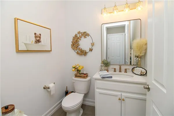 a bathroom with a toilet sink vanity and mirror