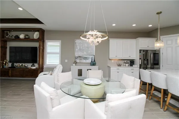 a living room with furniture a flat screen tv and kitchen view