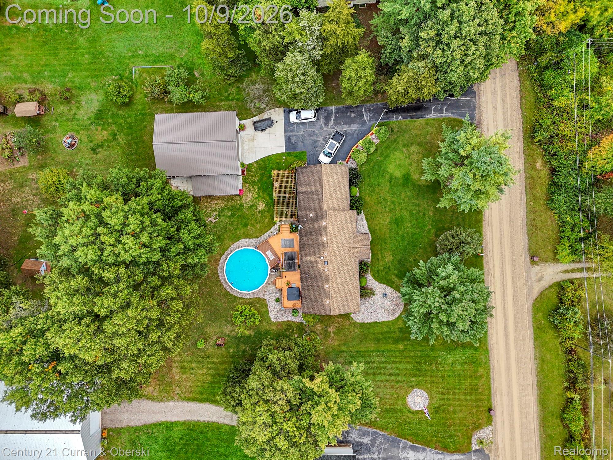 43040 Willis Road Belleville, MI 48111 - Photo 62 of 65 Expansive property with an above-ground pool, surrounding wood-finish decking, and a detached structure with a metal roof