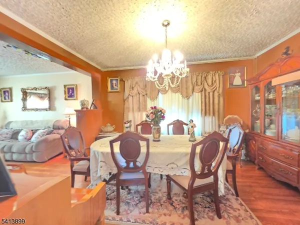 a view of a dining room with furniture a chandelier and wooden floor