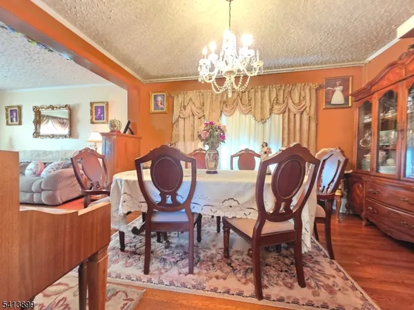 a view of a dining room with furniture a chandelier and wooden floor