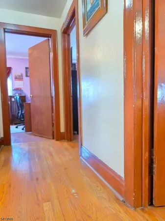 a view of hallway with livingroom and wooden floor