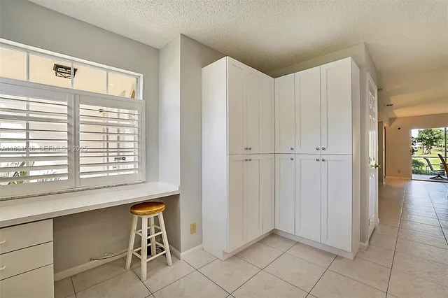 a view of an empty room with closet and a window