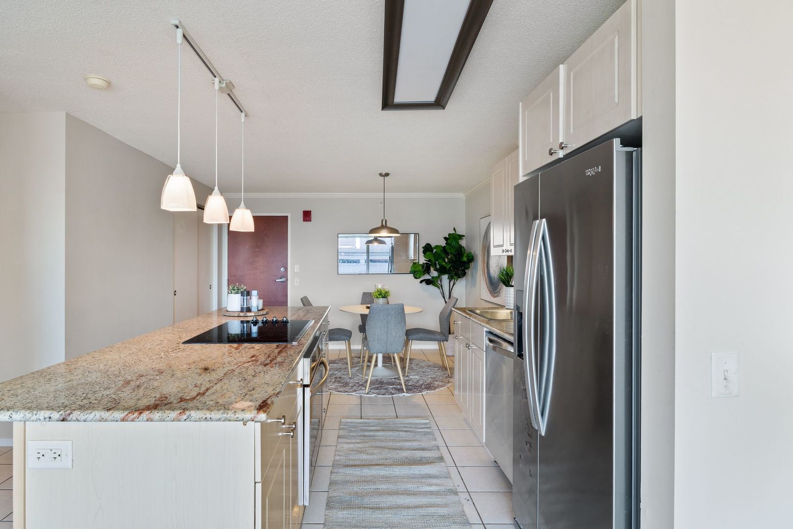 800 Elgin Road, Unit 1218 Evanston, IL 60201 - Photo 5 of 26 a kitchen with stainless steel appliances granite countertop a refrigerator a sink dishwasher and a stove with wooden floor