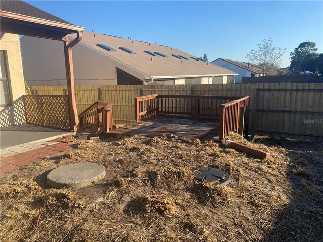 a view of backyard with wooden fence
