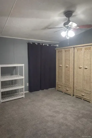 a view of an empty room with a chandelier fan