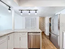 a kitchen with kitchen island granite countertop a sink cabinets and wooden floor