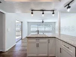 a large kitchen with a lot of counter space and wooden floor